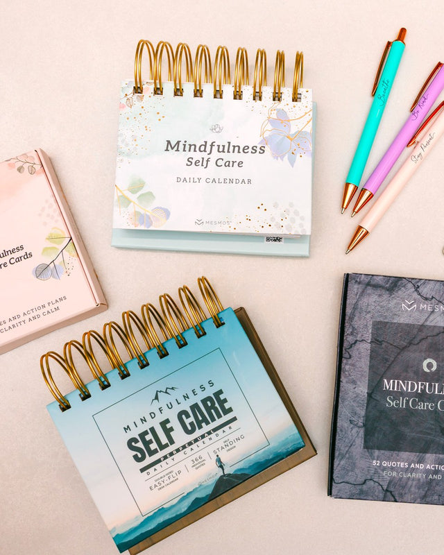 Mesmos Mindfulness daily calendars, self care cards and pastel pens on a desk