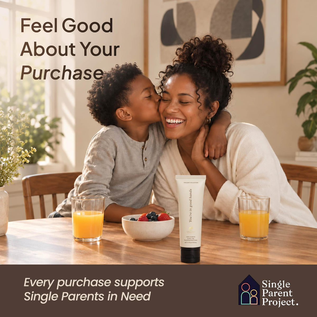 Mother being kissed by her son at breakfast with a vanilla hand cream tube; purchases support the Single Parent Project-
