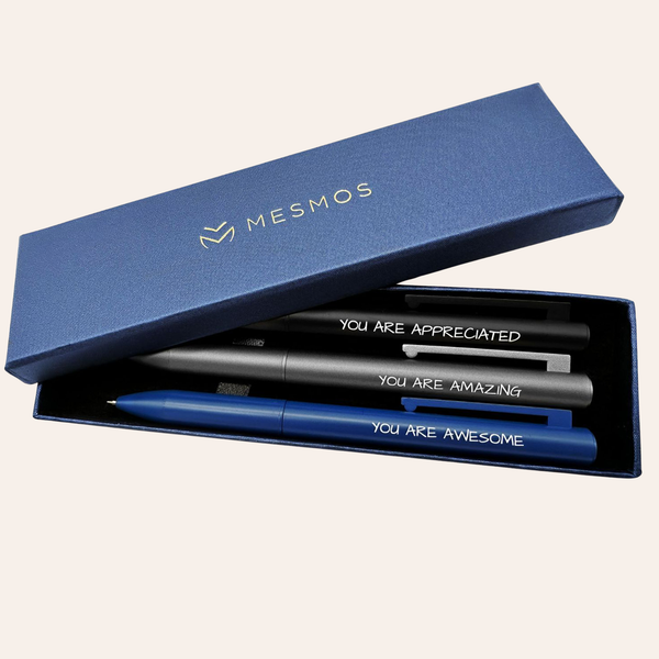Three dark metal pens in an open navy Mesmos gift box, engraved You Are Appreciated, You Are Amazing and You Are Awesome.