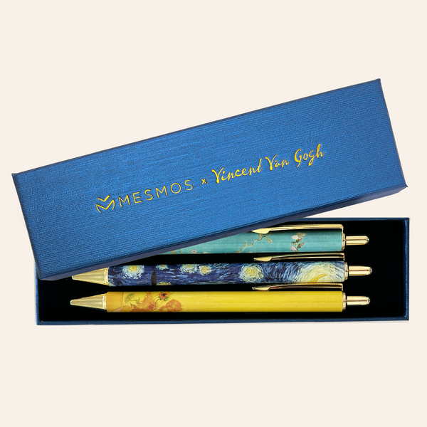 Two pens printed with Van Gogh artwork in an open navy Mesmos gift box.