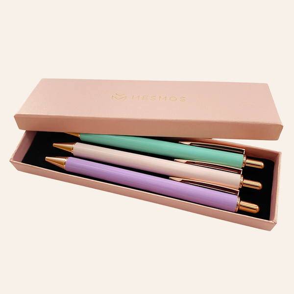 Four pastel pens with rose gold trim in an open pink Mesmos gift box.