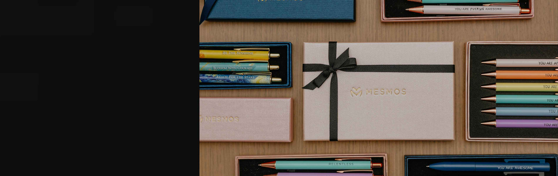 Collection of colored pencils and a gift box on a wooden surface